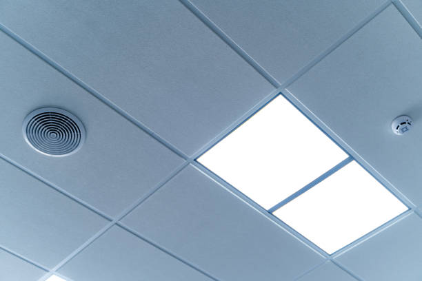 istock Security and fire alarm on the ceiling in administrative building. Square lamps built inside the ceiling. 1273852524