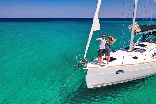 Young couple on anchored sailboat at Olib island, Croatia. View from drone.