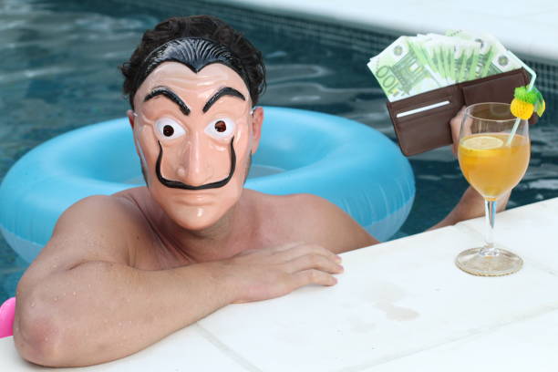 Man wearing a mask holding euros in swimming pool Man wearing a mask holding euros in swimming pool. pool at the crook stock pictures, royalty-free photos & images