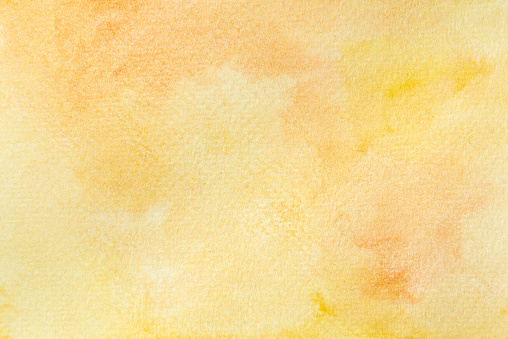 Handmade abstract watercolor on paper wallpaper. Hand painted orange and yellow watercolor background.