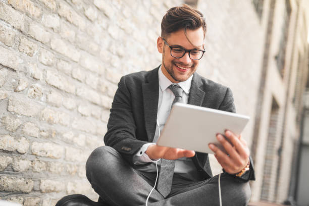 cheerful businessman sitting casually on a bench - hipster people surfing the net internet imagens e fotografias de stock