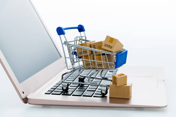 istock Shopping cart with small boxes on laptop keyboard 1273858115