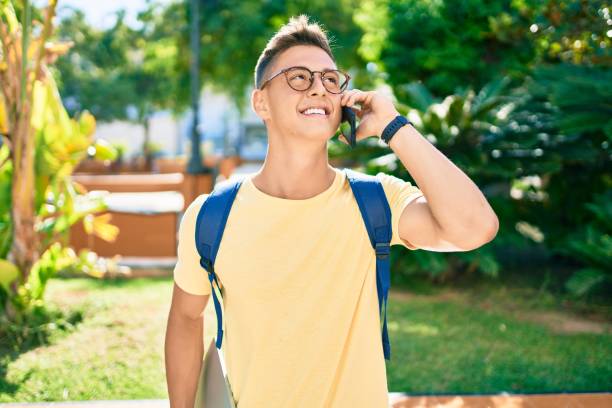 istock Young hispanic student smiling happy using smartphone walking the university campus 1273858369