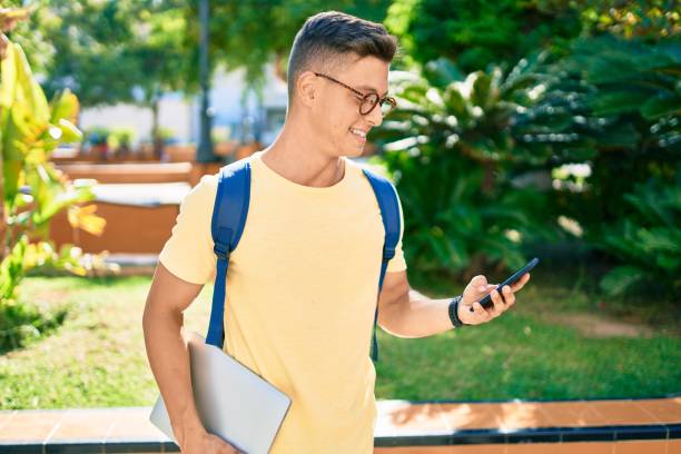 istock Young hispanic student smiling happy using smartphone walking the university campus 1273858397