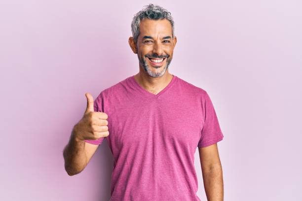 hombre de pelo gris de mediana edad con ropa casual sonriendo feliz y positivo, pulgar hacia arriba haciendo excelente y signo de aprobación - one mature man only fotografías e imágenes de stock