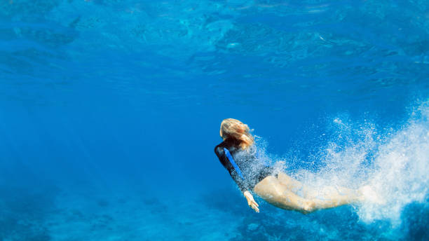 istock Young woman diving underwater 1273860692