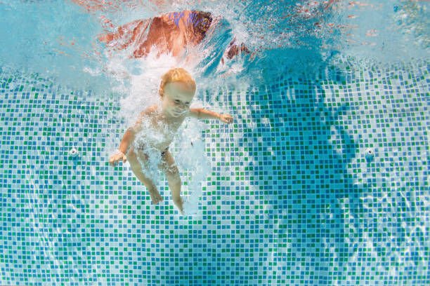 istock Happy child dive underwater with fun in swimming pool 1273861449