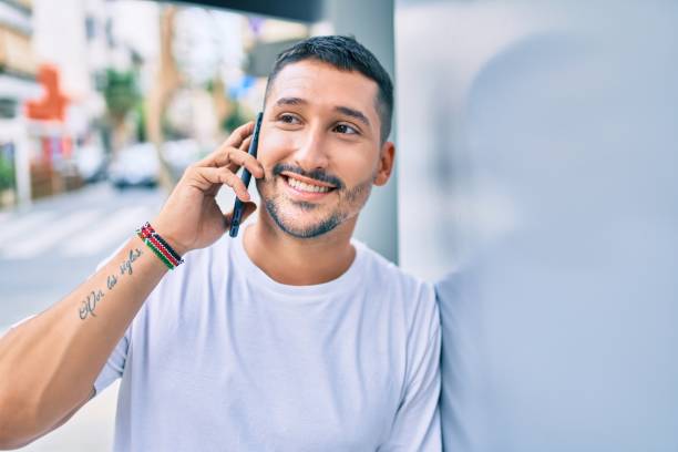istock Young hispanic man smiling happy talking on the smartphone leaning on the wall 1273863650