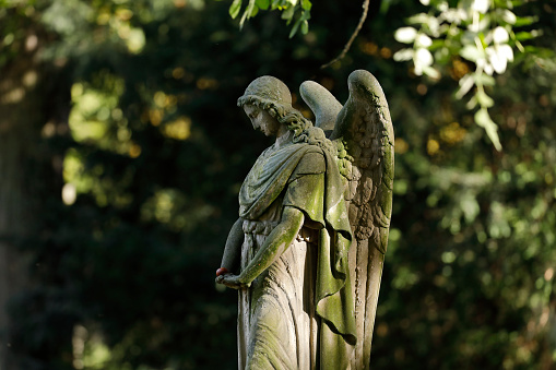 Weathered old angel statue on a cemetery in Germany