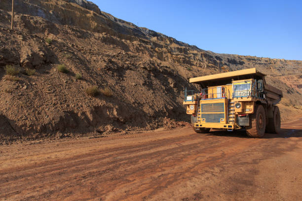 un grand benne de carrière est dans une carrière rouge - mine road photos et images de collection