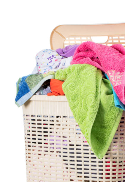 istock Laundry basket full of dirty washing (isolated on white) 1273868559