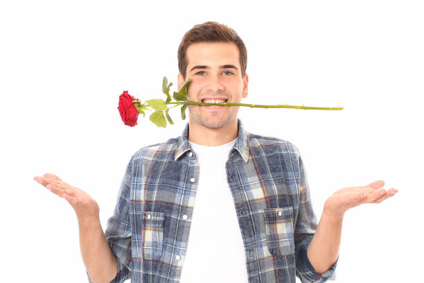istock Romantic young man smelling red rose isolated on white. Mock up and copy space. Valentines day 1273869252