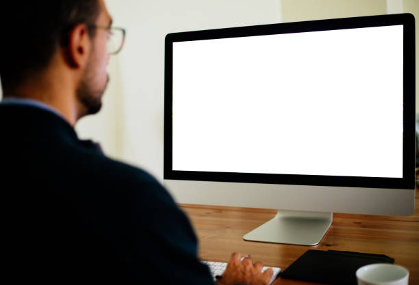 homme utilisant le pc de bureau avec l’écran vide - regarder par dessus son épaule photos et images de collection