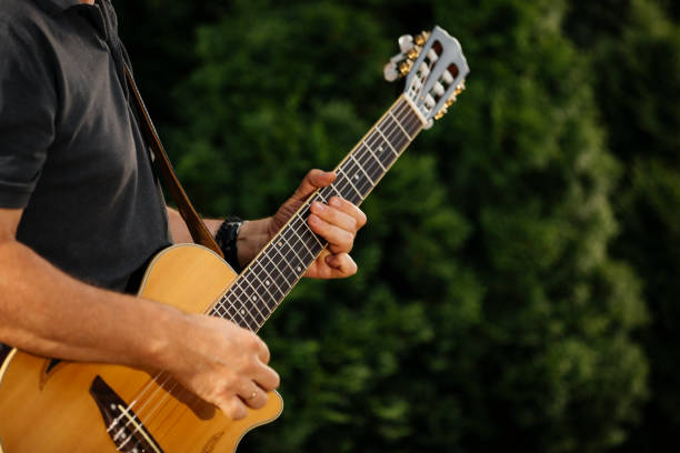 Close up of male hands playing acoustic guitar. stock photo