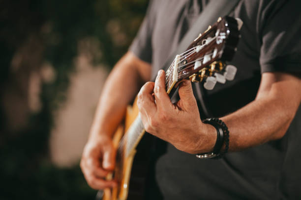 Close up of male hands playing acoustic guitar. stock photo