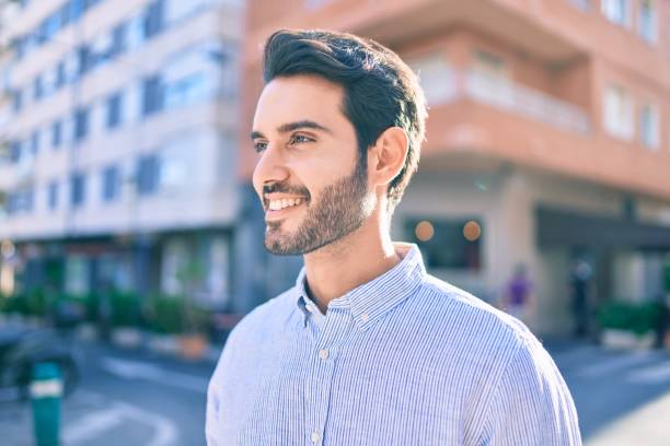istock Young hispanic man smiling happy walking at the city. 1273875584