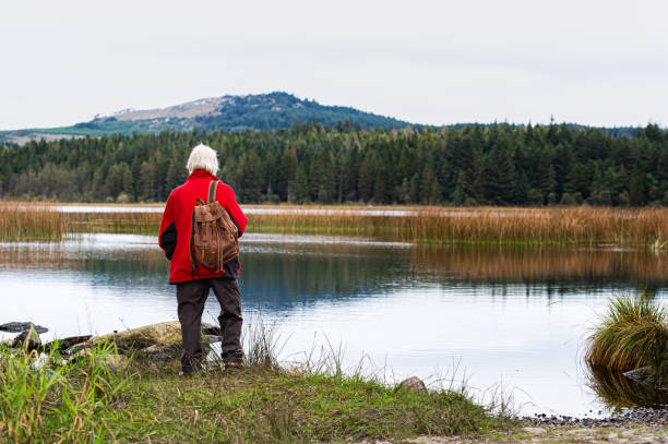 istock Active senior man standing beside a Scottish loch on an overcast summer day 1273875792