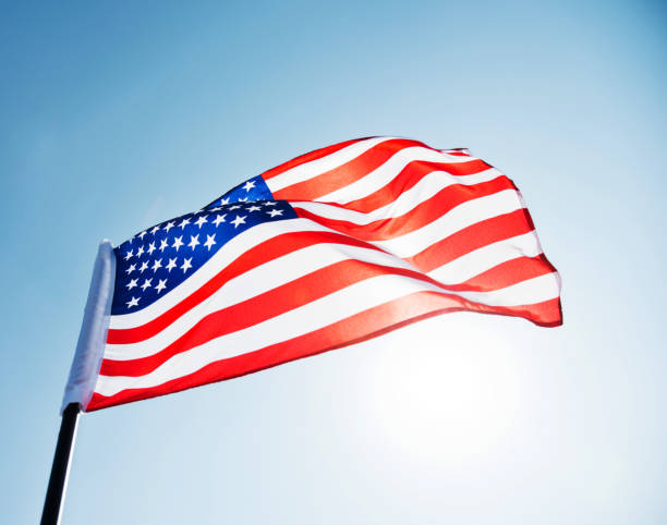 istock American flag waving against blue sky 1273875836