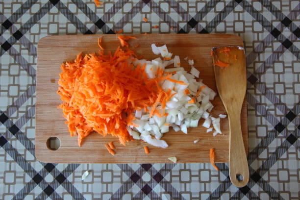 istock Carrots and onion on a cutting board 1273876275