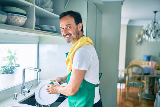 istock Middle age man with beard smiling happy washing dishes at home 1273876299