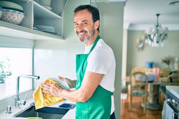istock Middle age man with beard smiling happy washing dishes at home 1273876330