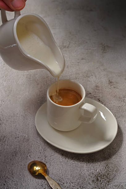 istock pouring milk into a cup of coffee 1273876425
