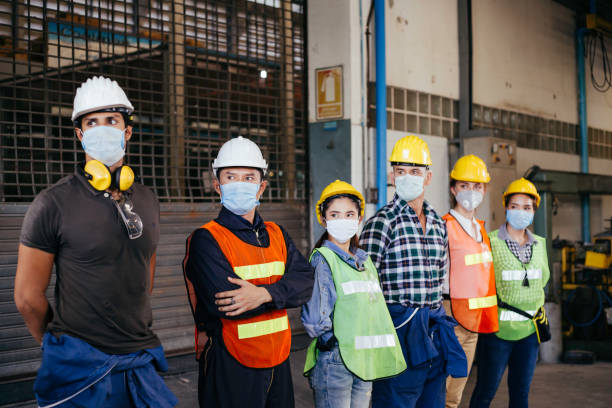 istock Group of industrial or engineer corporate workers wear protective mask and hard hat helmet standing line up and looking in same direction, industry manufacturing factory people  working with visions 1273876607
