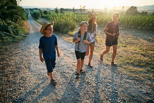 Mother and three kids hiking on dirt road in Tuscany.
Nikon D850