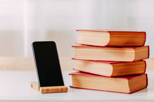 istock School supplies. Big red books and smartphone on the table. Home study 2020. 1273880461