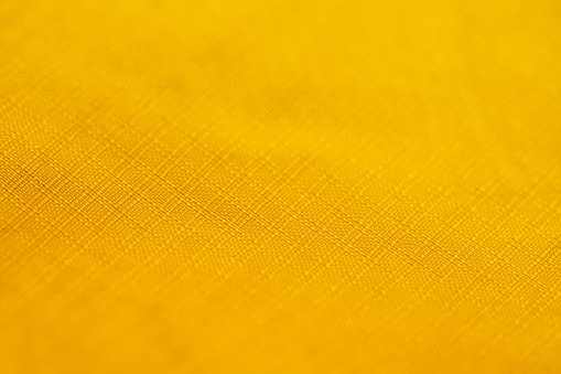 Yellow fabric background. Yellow cloth waves background texture. Yellow cloth textile material.