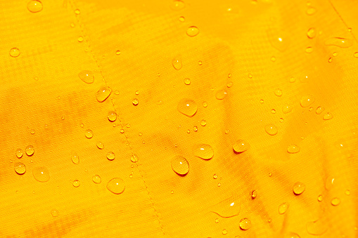 Water drops on the orange waterproof fabric