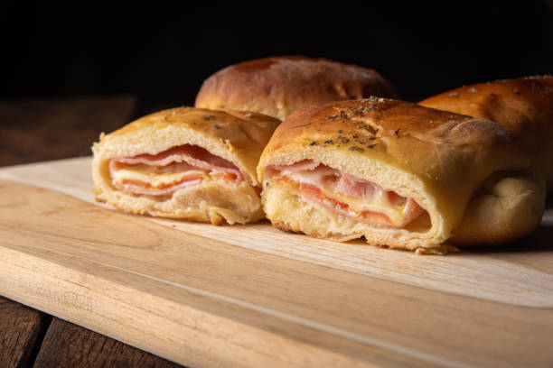istock Homemade bread stuffed with cheese and ham with black background. Low key image, selective focus. 1273883004