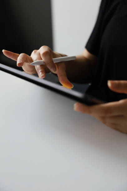 istock Close up of female hand using digital pen writing on digital tablet screen 1273883159