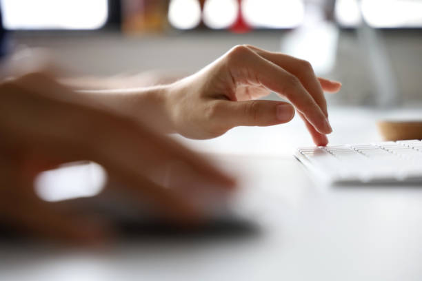 Female hands typing on a white computer keyboard Female hands typing on a white computer keyboard enter key computer keyboard computer key white stock pictures, royalty-free photos & images