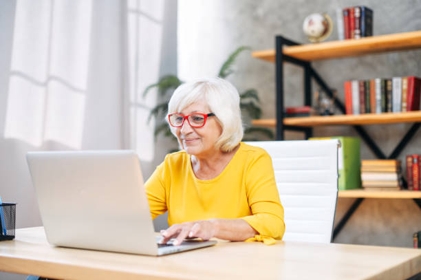 istock Senior woman is using laptop for work indoor 1273888523
