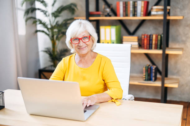 istock Senior woman is using laptop for work indoor 1273888532