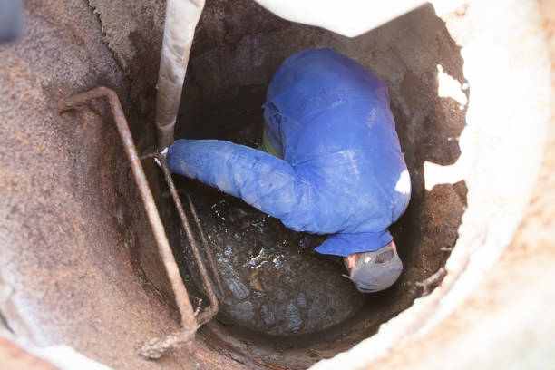 istock Worker cleans the sewer hatch.A worker cleans a sewer hatch. A man in the hatch. 1273888608