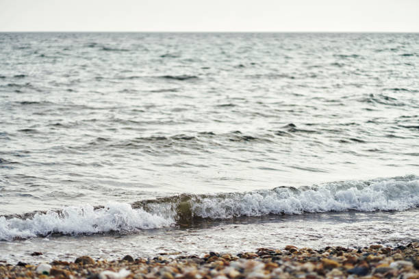 istock Front View Of One Foamy Wave Crashing On Rocky Beach 1273888866