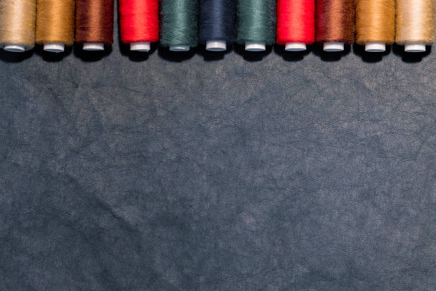 istock Top view of sewing supplies, multicolored sewing threads, on dark background. 1273889102