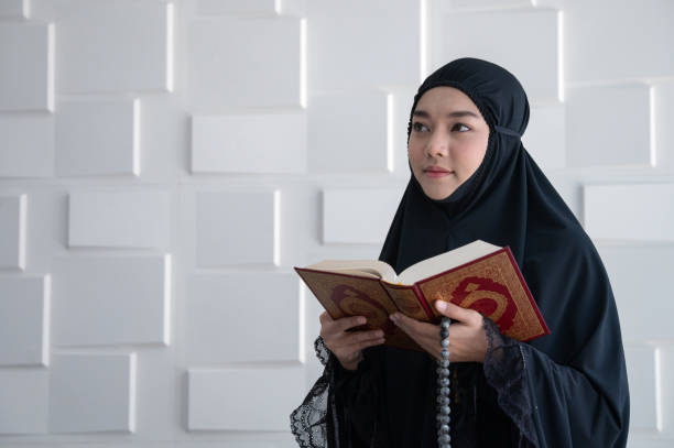 mujer musulmana rezando y leyendo el libro del corán - women open traditional culture human hand fotografías e imágenes de stock