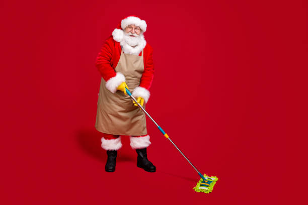 foto a figura intera di capelli grigi bianchi barbuto babbo natale lavare il pavimento mop x-mas pulizia indossare grembiule rosso costume copricapo berretto isolato brillante lucentezza colore sfondo - personal accessory cap christmas santa claus foto e immagini stock