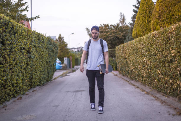 istock Young boy going to school / university by skateboard 1273891898
