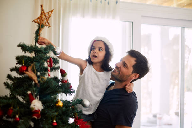istock Father and daughter decorating the Christmas tree. 1273894154