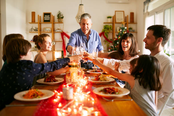 grandfather proposing a toast at christmas dinner in buenos aires - christmas dinner imagens e fotografias de stock