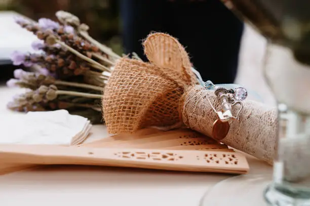 Photo of Close up of a lavender wedding bouquet with traditional bridal symbols