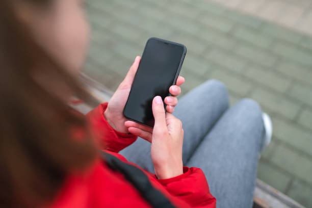 istock Woman uses smartphone outdoors 1273895676