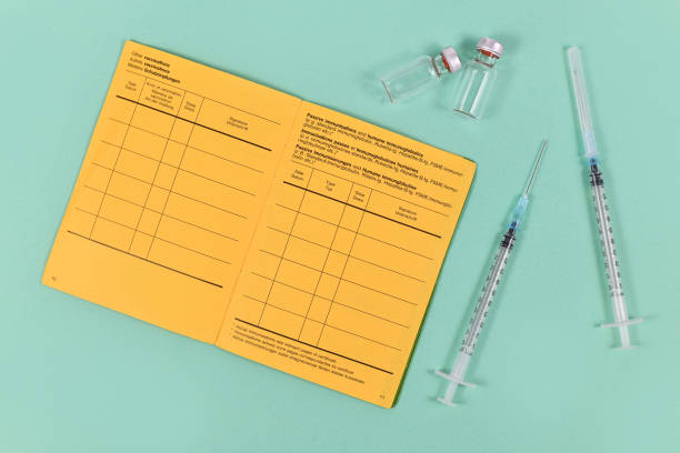 注射器、バイアル、黄色の黄色の国際予防接種証明書によるワクチン接種の概念 - yellow card ストックフォトと画像