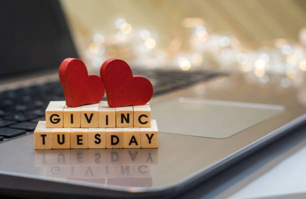 GIVING TUESDAY letter blocks concept on laptop keyboard Letter blocks concept on laptop keyboard giving tuesday stock pictures, royalty-free photos & images