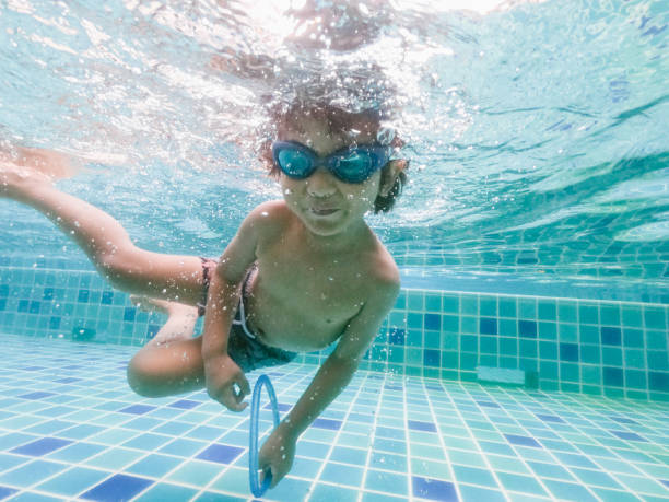 istock Asian little boy swimming and pick up objects underwater 1273898604