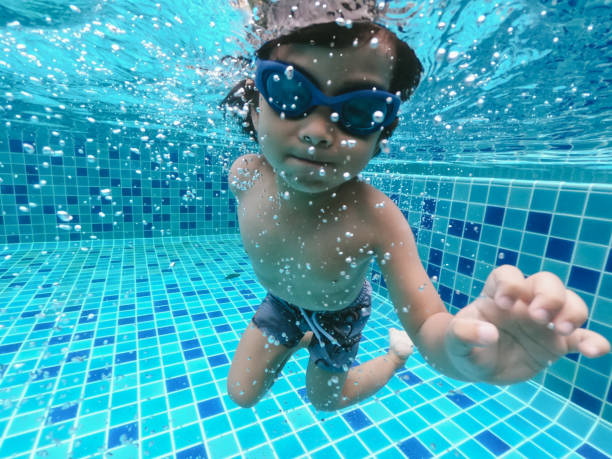 istock Asian little boy swimming and pick up objects underwater 1273898608